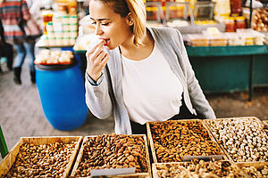 Frau knabbert Nüsse auf dem Markt